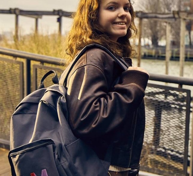 young woman, long brown hair, LIM College backpack, leather coat, South Cove Park
