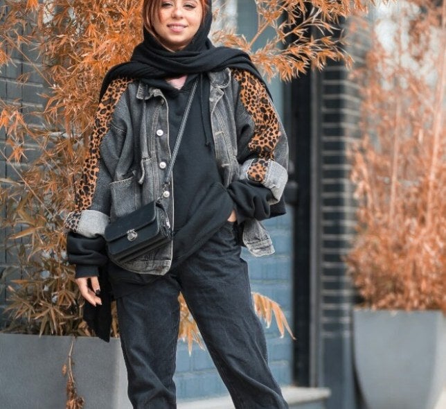 model in black clothing, red hair, decorative plant potters, cement paving stones