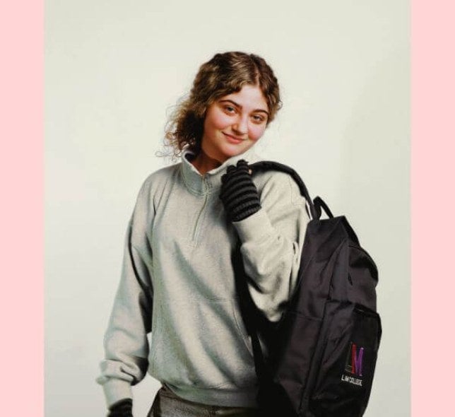 young woman, blond hair, LIM backpack, solid background