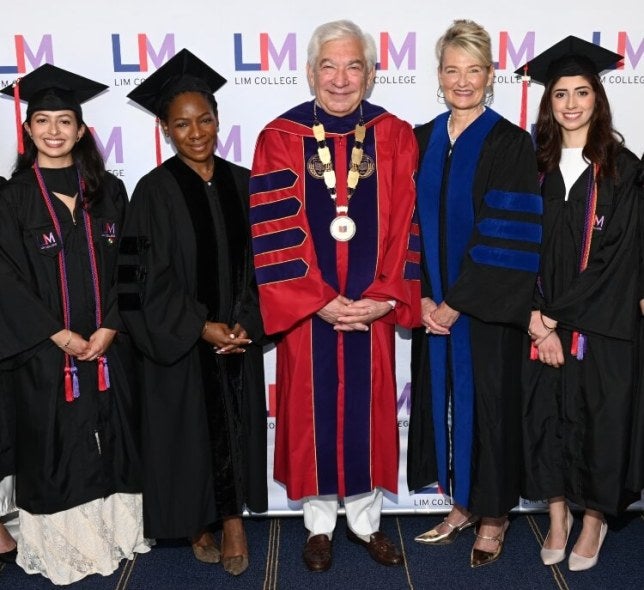 2026 LIM College Commencement step and repeat, Andrea, Tamika, Ron, Elyce, and Fernanda wearing academic graduation regalia 