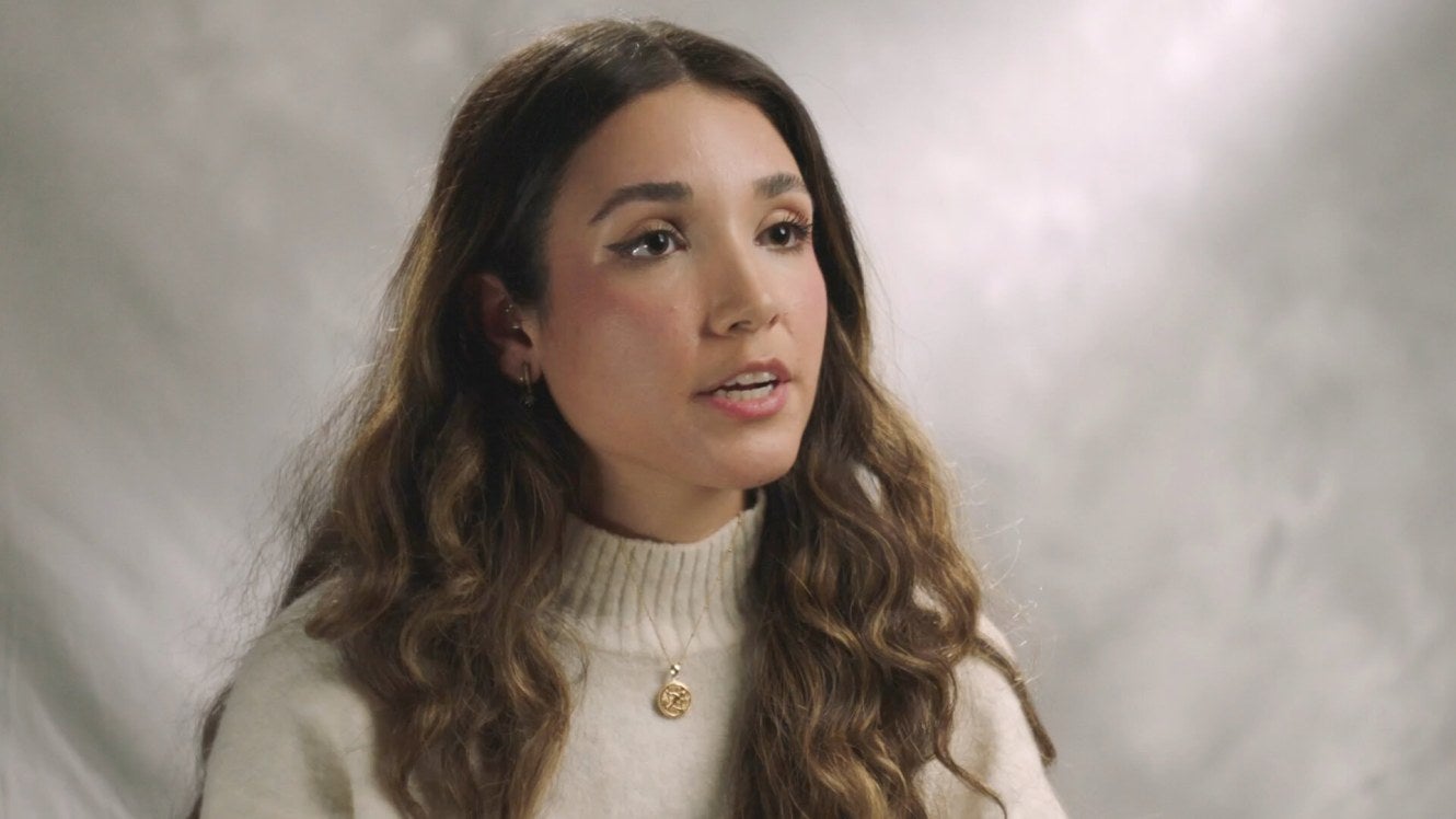 woman in a cream turtleneck talking