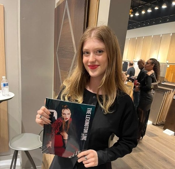 young woman, long red hair, holds copy of Lexington Line magazine