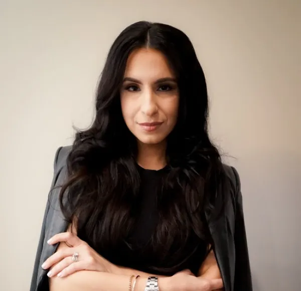 woman, professional photo, dressed in black with jacket folded over shoulders, arms folded