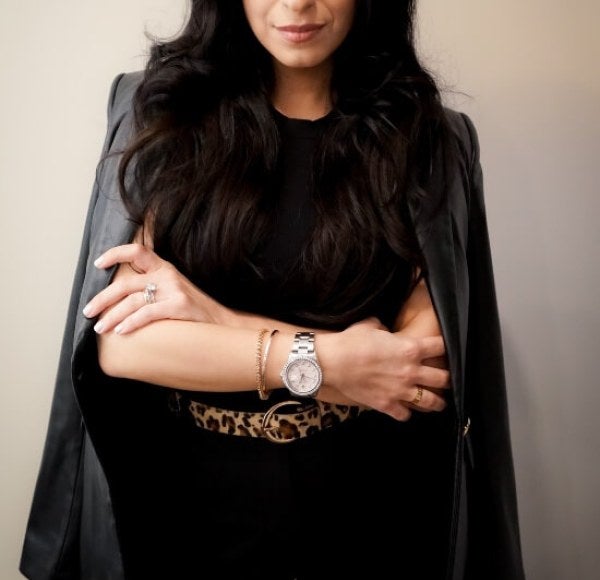 woman, professional photo, dressed in black with jacket folded over shoulders, arms folded