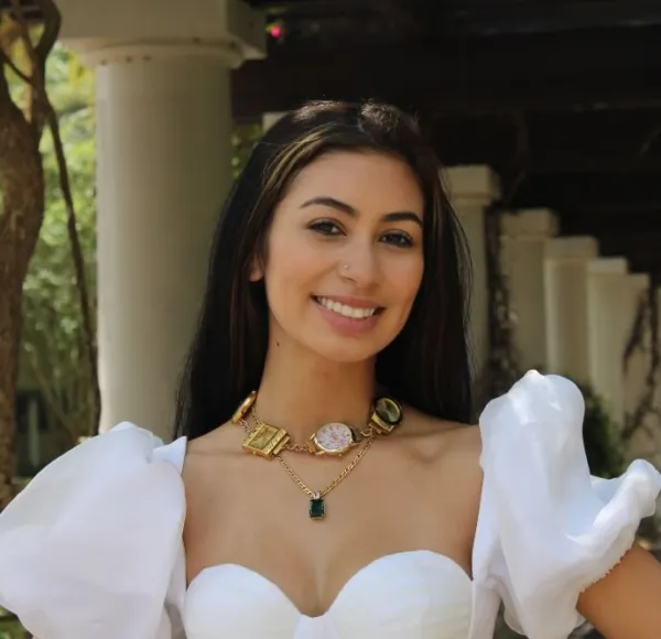 young woman, white formal dress, necklace with thick charms, outdoor environment