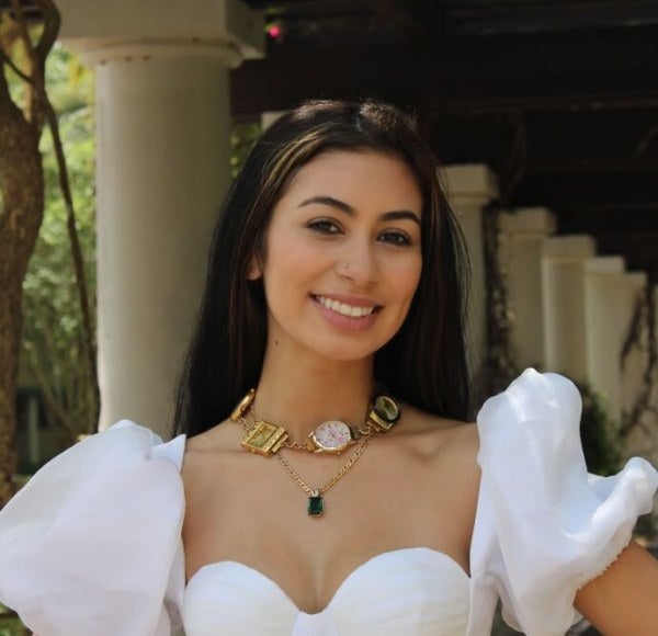 young woman, white formal dress, necklace with thick charms, outdoor environment