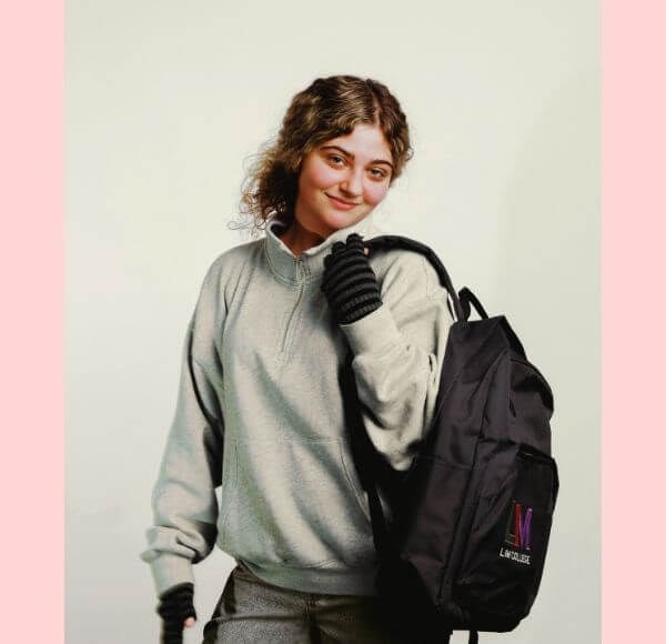 young woman, blond hair, LIM backpack, solid background