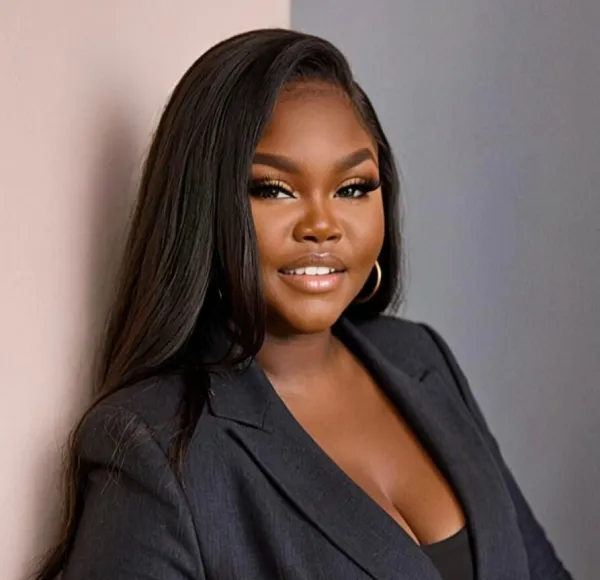 woman with long dark hair, earrings, charcoal business suit, medium shot
