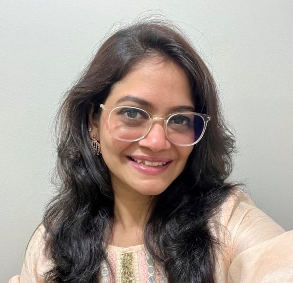 woman, long dark hair, glasses, light-colored blouse, selfie shot