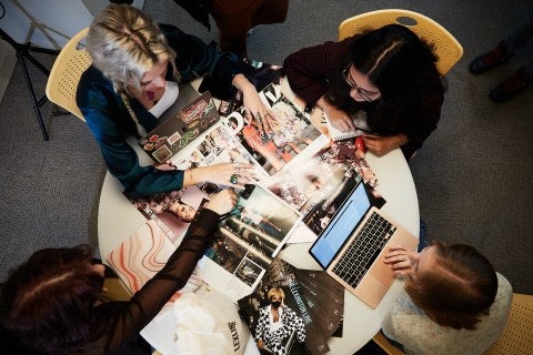 Four LIM students browsing through previous The Lexington Line issues