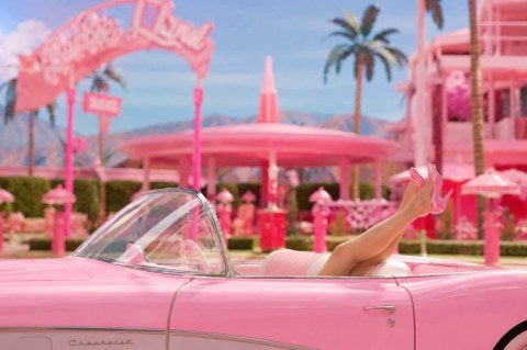 pink convertible, high-heeled legs visible, "Barbieland" setting