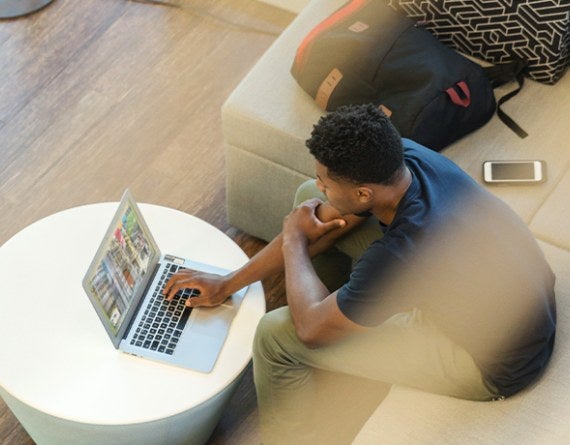 A bird's eye view of someone working indoors at a laptop.