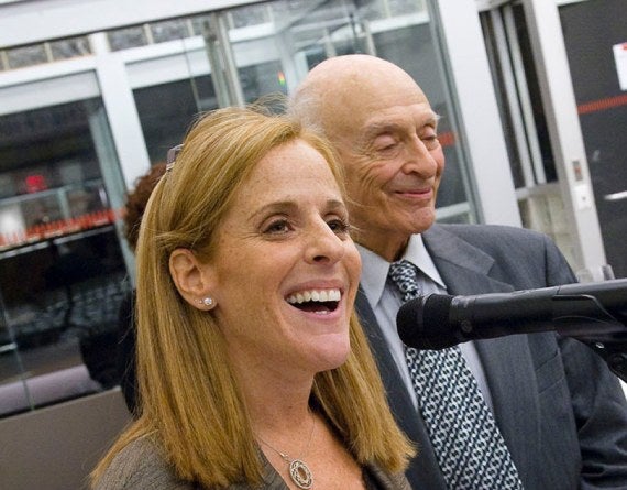 smiling man and woman at a microphone