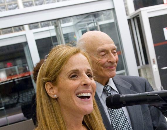 smiling man and woman at a microphone