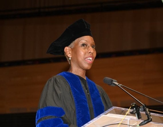 woman in academic doctoral robe at stage podium
