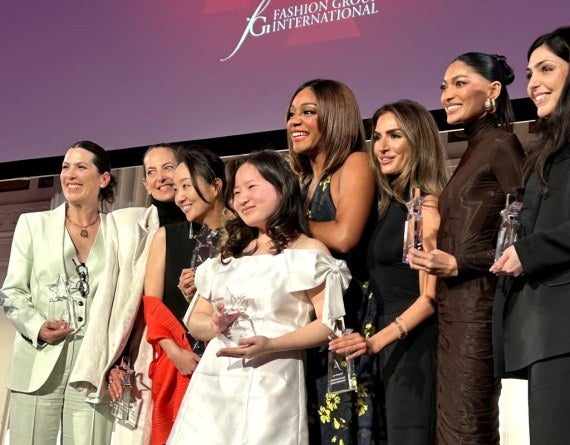 group of award recipients on Fashion Group International event stage.