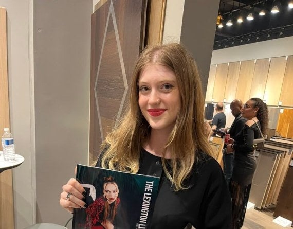 young woman, long red hair, holds copy of Lexington Line magazine
