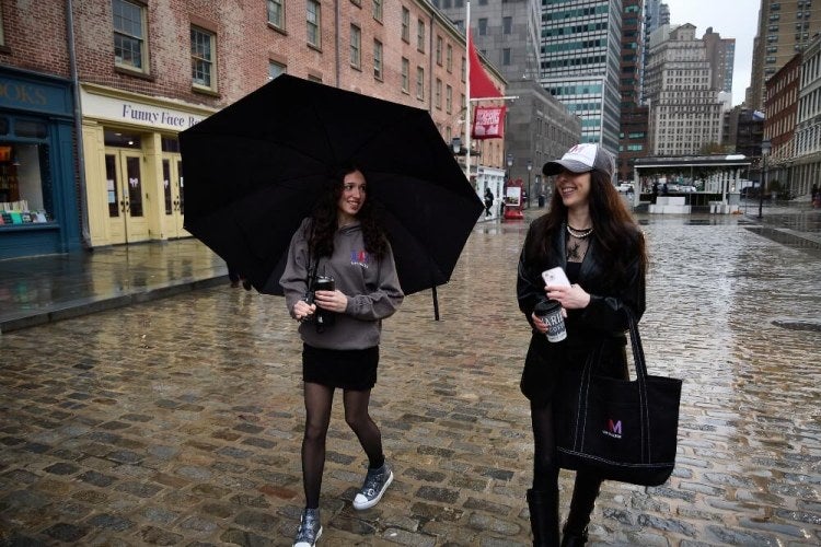 two students walk on the cobblestones near New York City's South Street Seaport