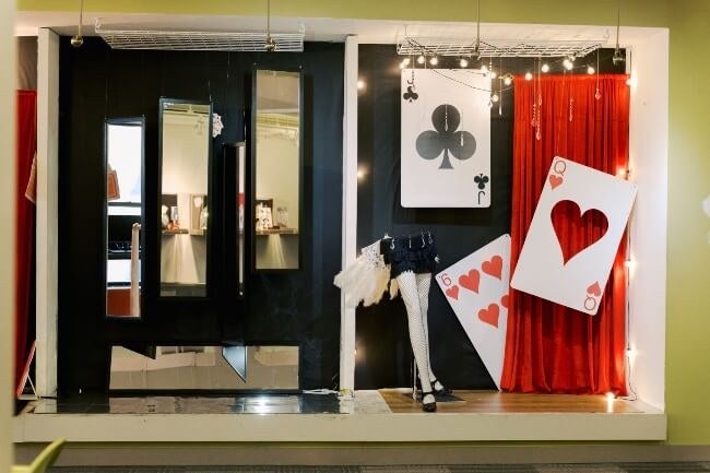 Visual Studies display, giant playing cards, vertical mirrors, red curtain, mannequin parts 