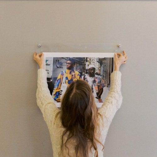 woman with long blond hair hands student's photo on campus
