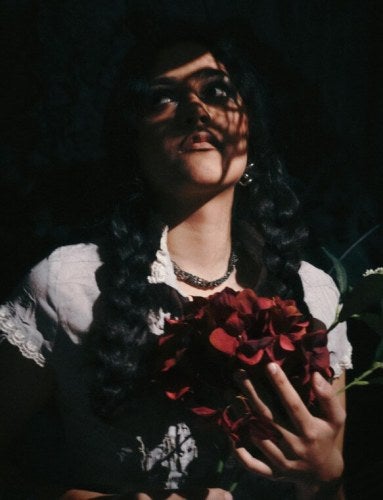 young woman in shadow, holding rose, artistic shot