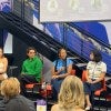 Several LIM College alumni sit on a panel in Maxwell Hall's student center. One of them holds a microphone.