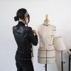 woman draping fabric on mannequin