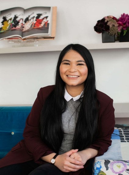 woman smiling at the camera sitting on a couch