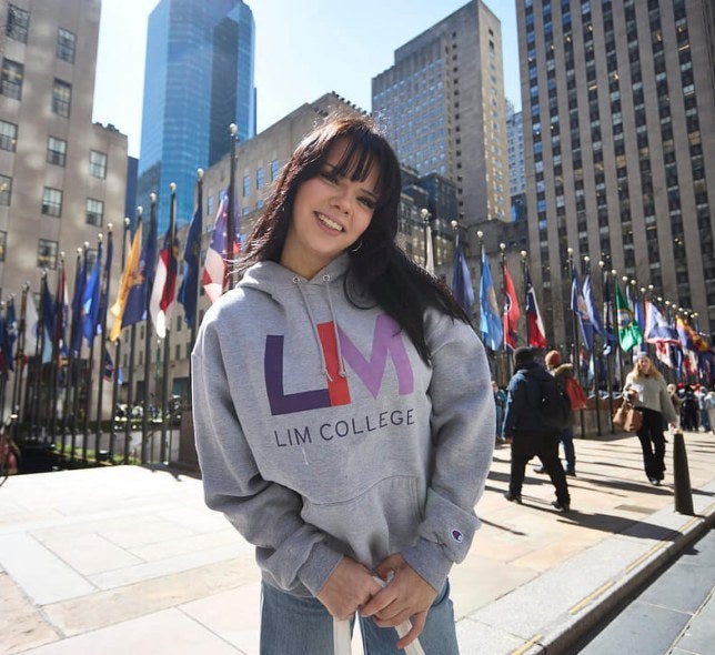 dark-haired young woman in LIM College hoodie, standing outdoors in Rockefeller Plaza